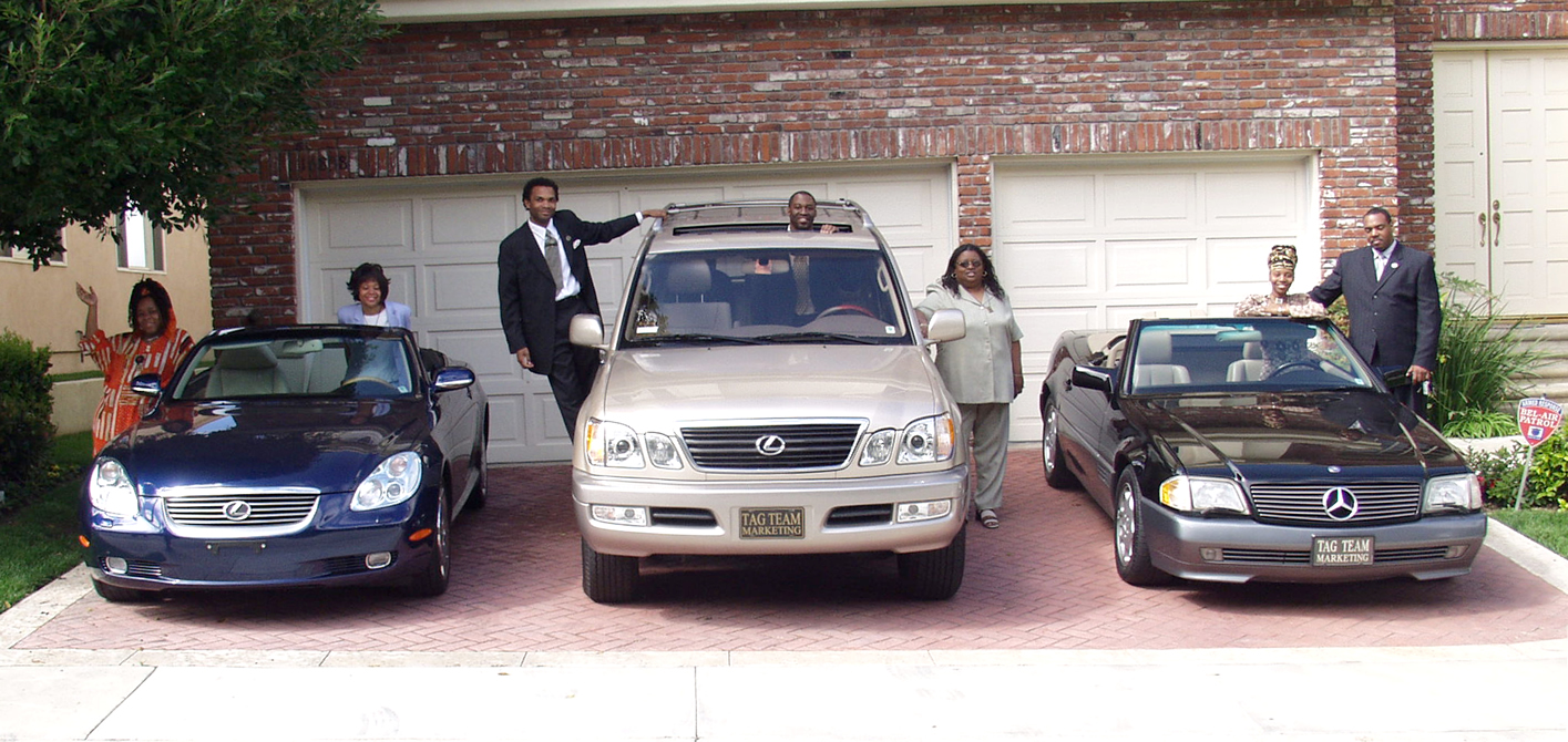 Team Leaders posing with cars at leadership retreat